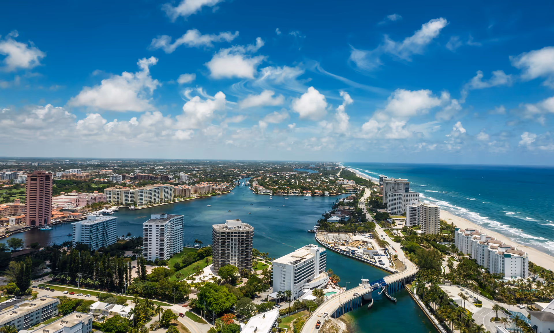 Aerial view of the Boca Raton Inlet linking Lake Boca to the Atlantic Ocean, with the Boca Raton Bridge and oceanfront coastline in Palm Beach County, Florida