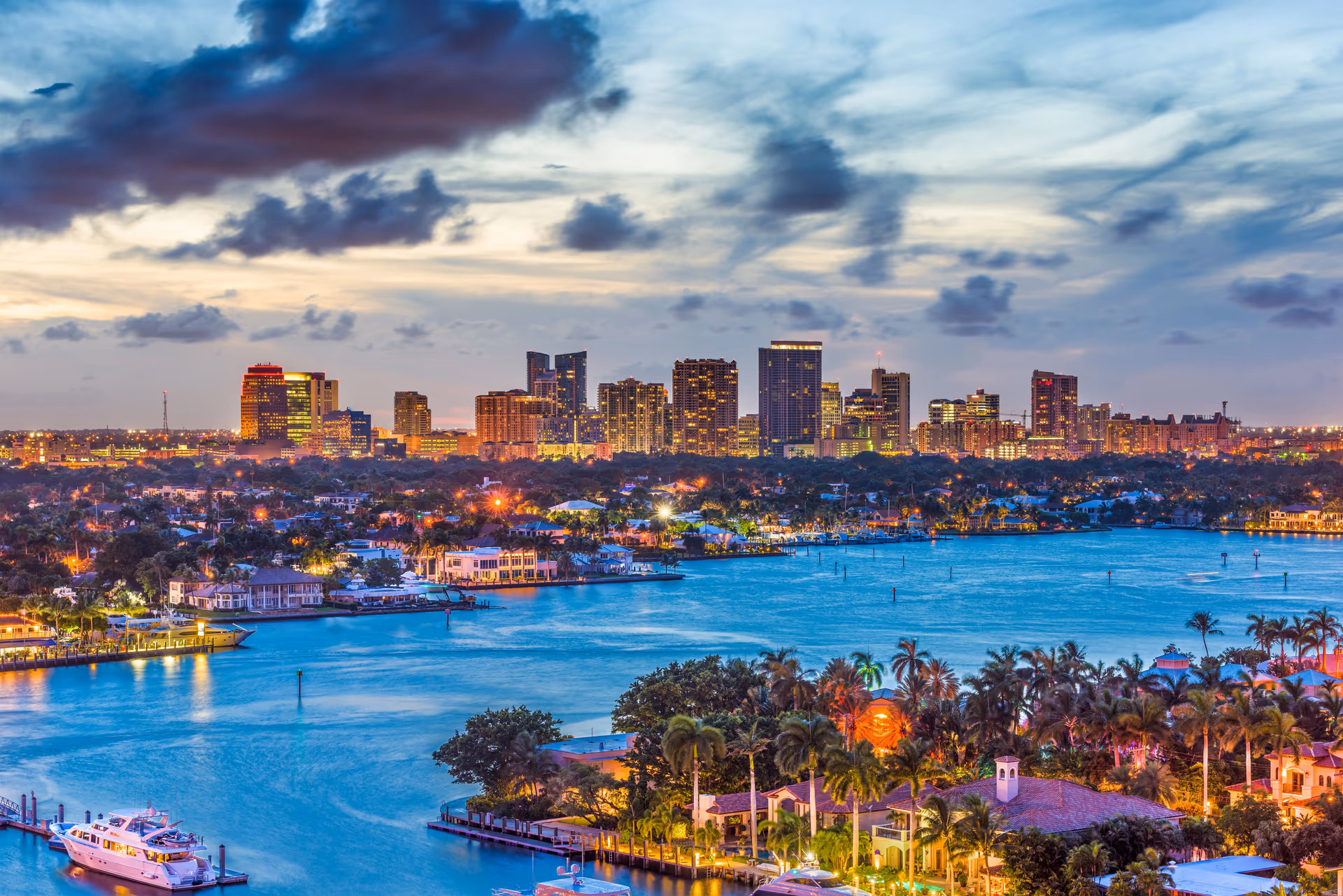 Fort Lauderdale downtown skyline at dusk seen across the Intracoastal Waterway with waterfront homes and yachts in Broward County, Florida